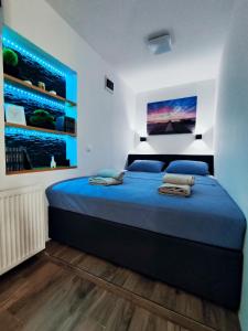 a bedroom with a large bed with blue sheets at Studio Apartment FortyOne in Orebić