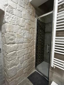 La salle de bains est pourvue d'une douche et d'un mur en pierre. dans l'établissement Holiday Home Cosimo, à Locorotondo
