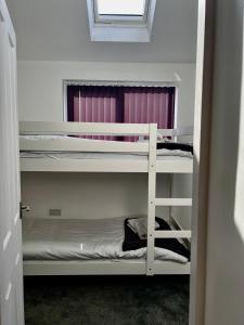 a room with two bunk beds and a window at St Andrews house Hotel in Preston