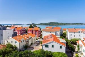 Un grupo de casas con techos anaranjados y el agua en Anne, en Srima