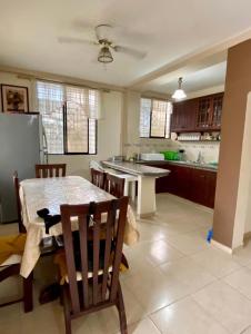 uma cozinha com uma mesa e cadeiras e um frigorífico em Jurado, Casa Hospedaje em Tonsupa