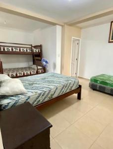 a bedroom with a bed and a table in it at Jurado, Casa Hospedaje in Tonsupa