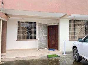 una casa con una porta e una macchina parcheggiata di fronte di Jurado, Casa Hospedaje a Tonsupa