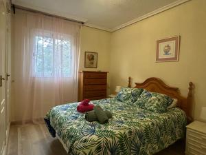 een slaapkamer met een bed met een teddybeer erop bij Apartment with Beach Views in Fuengirola
