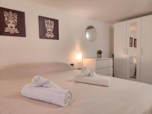 a bedroom with a large bed with towels on it at Don Vito's Home in Palermo