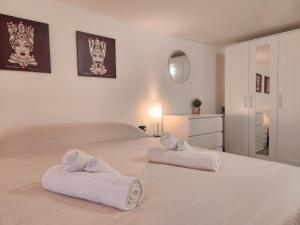 Un dormitorio con una cama grande con toallas. en Don Vito's Home, DsG2 Short Lets, 250 mt Metrò, en Palermo