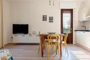 a kitchen with a table and chairs and a television at Appartamento i Limori in San Giuliano Terme