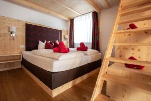 a bedroom with a large bed with red pillows at Piburg Studios in Oetz