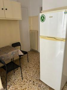 frigorifero bianco in una stanza con tavolo e sedie di Комната с общей баней karolou 10 ad Atene