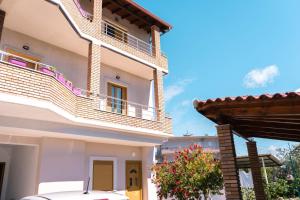 une maison avec un balcon et une voiture garée devant dans l'établissement Vila Anxhelo, à Vlorë