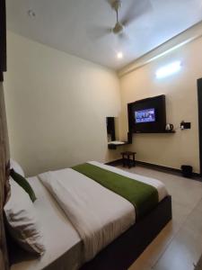 a bedroom with a bed and a flat screen tv at Hotel Olive Smart Stay in Agra