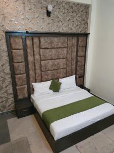 a bedroom with a large bed with a green blanket at Hotel Olive Smart Stay in Agra