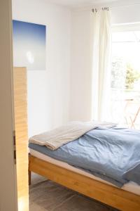 1 cama en un dormitorio con ventana en Gemütliche Wohnung mit kleiner Terrasse - Nah am Stadion Frankfurt und Flughafen en Mörfelden-Walldorf