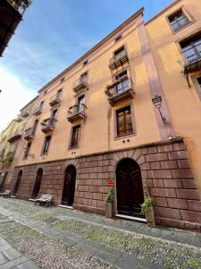 ein großes Backsteingebäude mit Fenstern und Türen darauf in der Unterkunft Sardinian Gallery Corso in Bosa