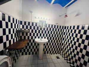 uma casa de banho com paredes em azulejo preto e branco e um lavatório. em Beautiful Beach em Arugam Bay
