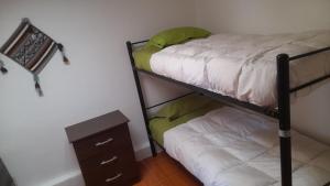 a bedroom with a bunk bed and a night stand at Hostal Open House in San Pedro de Atacama