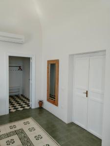 Habitación blanca con puerta y alfombra en Villa Bona, en Termini Imerese