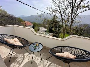 a balcony with two chairs and a table with a view at Apartman Ivan with pool in Zagvozd