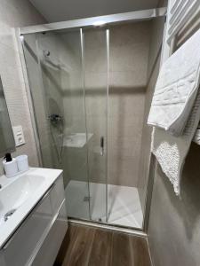 une douche avec une porte vitrée dans une salle de bain dans l'établissement White House, Castellón de la Plana