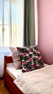una cama con una almohada junto a una ventana en Beautiful rooms in the center, en Szczecin
