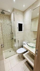 een badkamer met een toilet, een douche en een wastafel bij F3 Chic et Cosy très accessible in Dakar