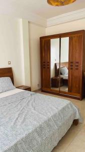 een slaapkamer met een bed en een grote spiegel bij F3 Chic et Cosy très accessible in Dakar