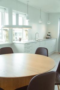 een keuken met een houten tafel met stoelen en een wastafel bij 3 BR Villa for 7 guests in Tórshavn in Tórshavn