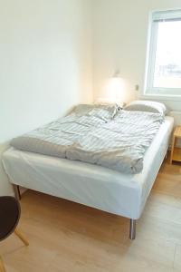 een bed in een witte kamer met een raam bij 3 BR Villa for 7 guests in Tórshavn in Tórshavn