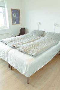 een groot wit bed in een kamer met een stoel bij 3 BR Villa for 7 guests in Tórshavn in Tórshavn