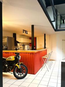 ein Motorrad, das neben einer roten Theke in einer Küche parkt in der Unterkunft Loft Atypique de 240m- 3 chambres in Saint-Denis