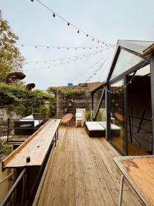eine Terrasse mit einer Holzterrasse mit einem Holztisch in der Unterkunft Loft Atypique de 240m- 3 chambres in Saint-Denis