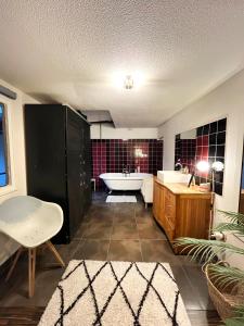 ein Badezimmer mit einer Badewanne, einem Waschbecken und einer Badewanne in der Unterkunft Loft Atypique de 240m- 3 chambres in Saint-Denis