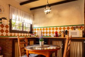 Il comprend une cuisine équipée d'une table, de chaises et d'un four micro-ondes. dans l'établissement El Pinsapo Casa Rural, à Cuevas del Becerro