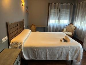 um quarto com uma cama grande e uma cadeira em Bakiola em Arrankudiaga