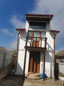 a small white building with a clock on it at La Vodita SRL in Filiaşi
