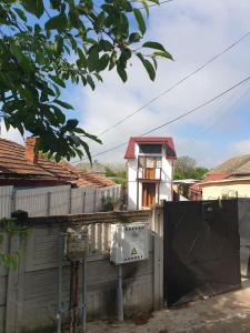 a house behind a fence with a gate and a building at La Vodita SRL in Filiaşi