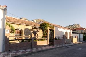 un bâtiment avec une clôture sur le côté d'une rue dans l'établissement El Pinsapo Casa Rural, à Cuevas del Becerro