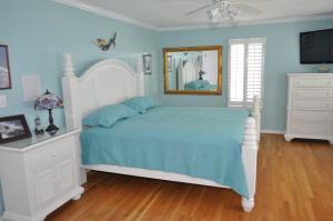 a bedroom with a white bed and a mirror at Surf's Up! in Virginia Beach