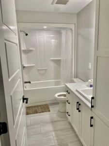 a white bathroom with a shower and a toilet at New built home close to airport Moncton, Dieppe in Dieppe