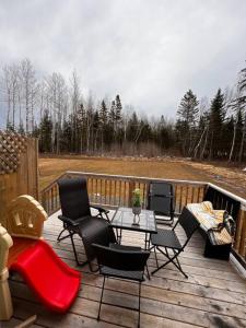 a deck with chairs and a table and a television at New built home close to airport Moncton, Dieppe in Dieppe
