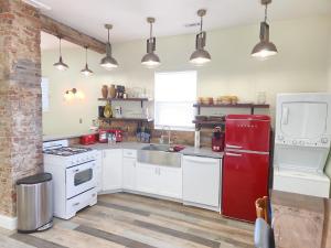 uma cozinha com armários brancos e um frigorífico vermelho em Orange Delite em Indianápolis