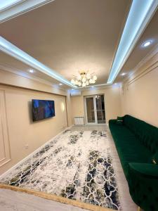 - un salon avec un canapé vert et un tapis dans l'établissement Отау сити, à Kamennaya Balka