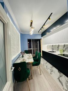 - une cuisine avec une table, des chaises vertes et un évier dans l'établissement Отау сити, à Kamennaya Balka
