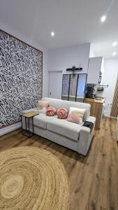 una sala de estar con un sofá y una alfombra en Le Charme Rosé, en Villejuif