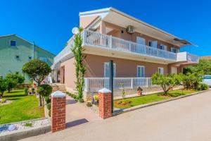 a house with a balcony and a yard at Apartments Anđelka in Bibinje