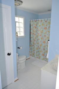 La salle de bains est pourvue de toilettes et d'un rideau de douche. dans l'établissement Surf's Up!, à Virginia Beach