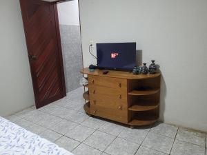 1 dormitorio con tocador y TV encima. en Quarto - Canto Juazeirense en Juazeiro do Norte