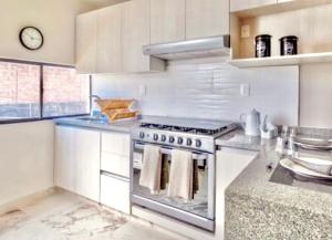 a kitchen with a stove top oven in a kitchen at Casa de las Palmas tu destino en Morelos in Alpuyeca