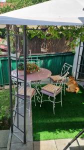 a table and chairs under a white canopy with a dog at Melisa Apartment Sarajevo in Sarajevo