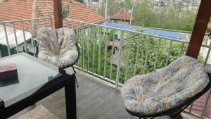 a balcony with two chairs and a table on a balcony at Melisa Apartment Sarajevo in Sarajevo